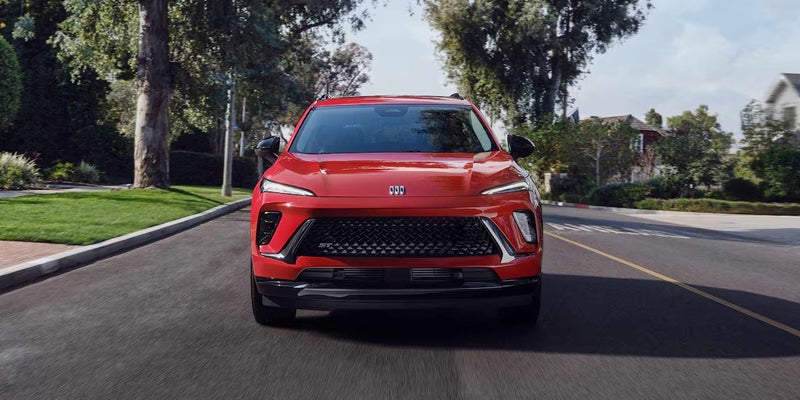 2026 Buick Envision in red, driving smoothly on a scenic highway
